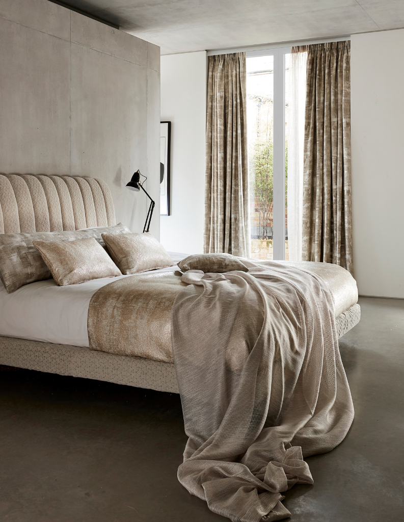 Gold curtains and bedding in a luxurious bedroom. 