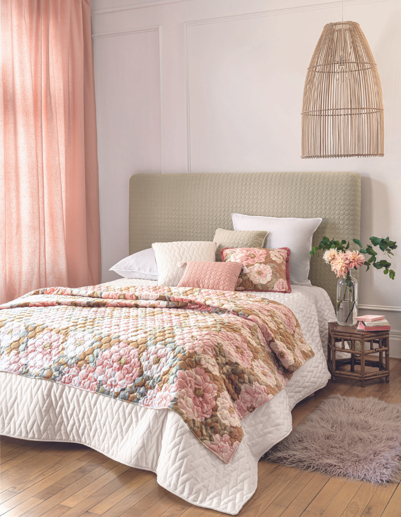 A stylish bedroom with pick curtains, cushions and throw. 