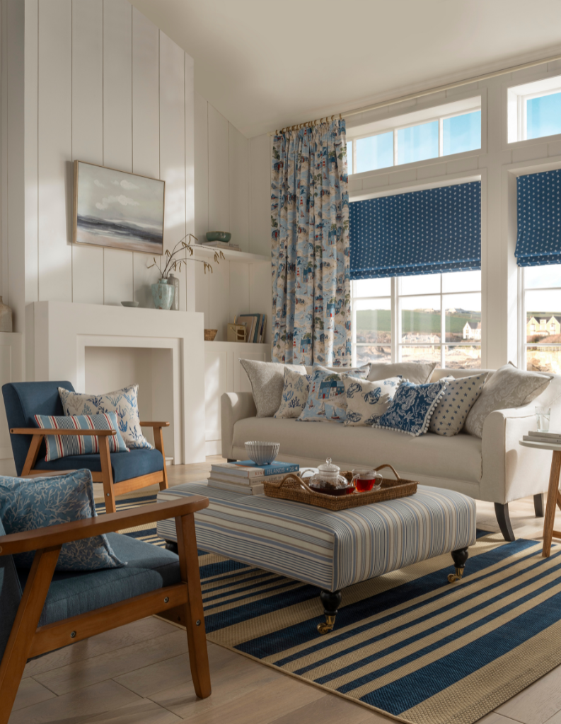 A coastal chic living room with blue patterned Roman blinds and curtains. 