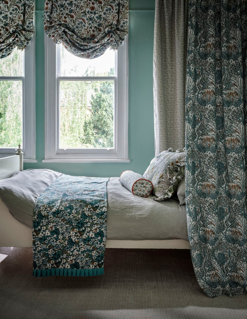 A bold patterned bedroom with floral curtains and bedding. 