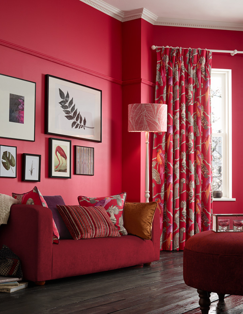 A wine red living room with bold curtains, sofa and home accessories. 