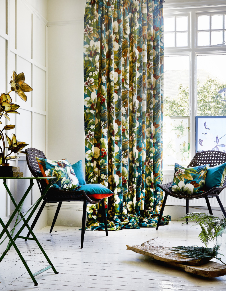 Vibrant floral curtains and cushions in a biophilia inspired living room.