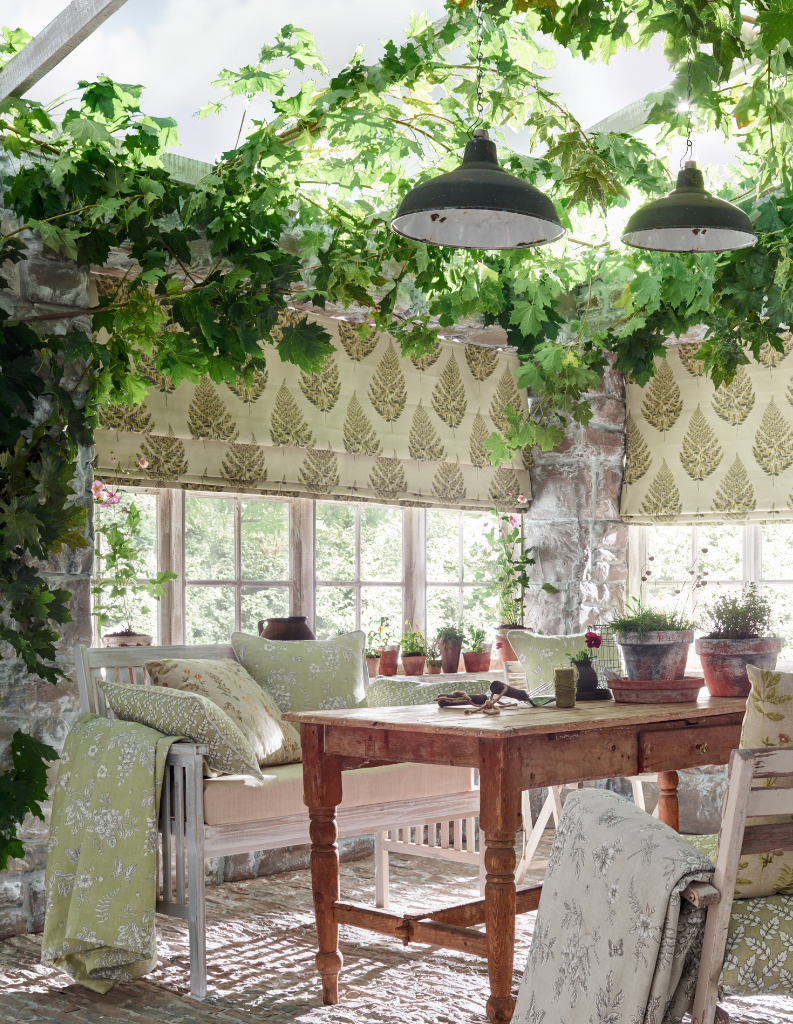 A biophilia inspired conservatory featuring floral pattern blinds and accessories alongside leafy plants.