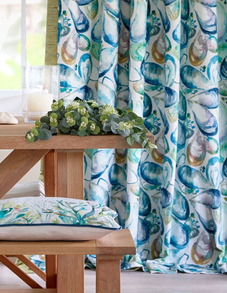 Transformative teal curtains and cushions with a coastal shell pattern. 