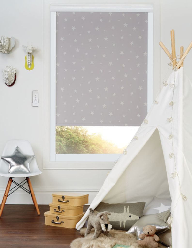 A relaxing child's room with star patterned blinds, toys and decorative elements. 