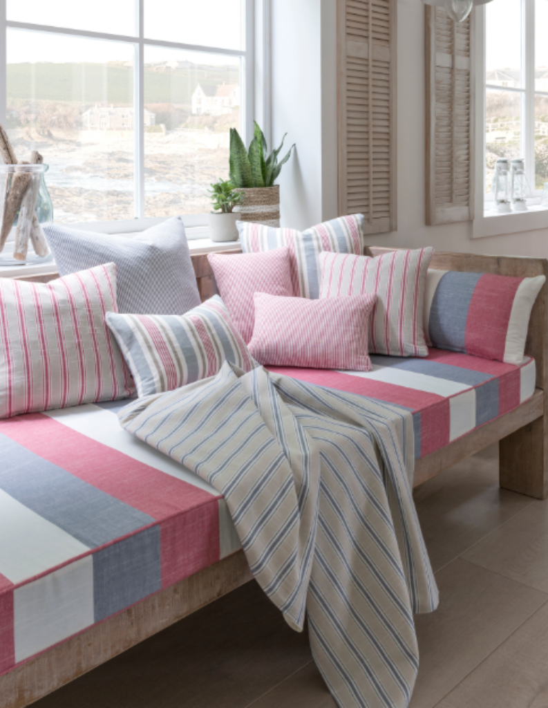 A selection of colourful striped cushions on a wide stripe sofa.