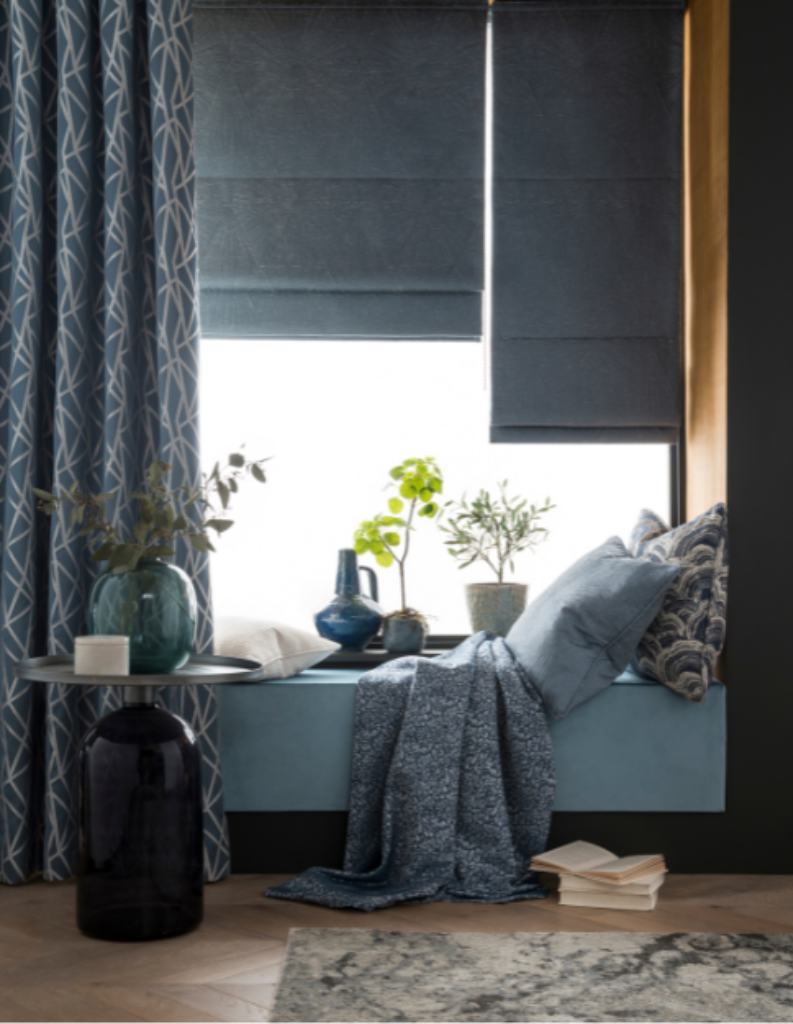 A mono-room featuring blue accents. The image includes blue curtains, blue Roman blinds and blue home accessories.