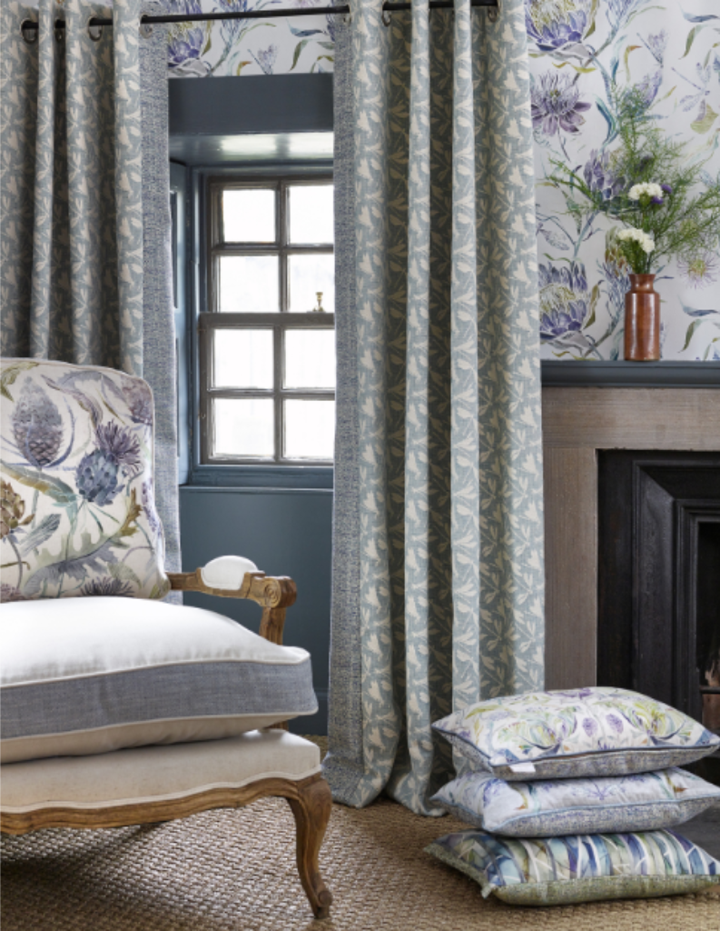 A country charm living room with patterned curtains, cushions and chair.