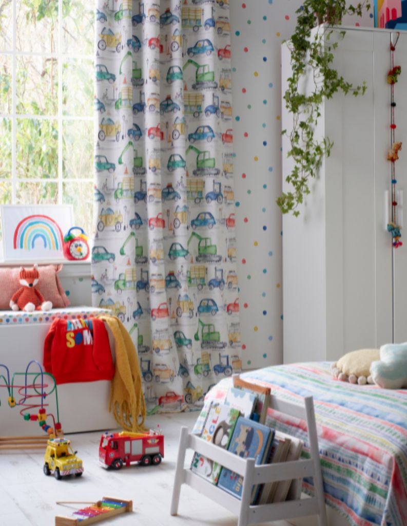 A colourful child's bedroom with fun curtains and home accessories. 