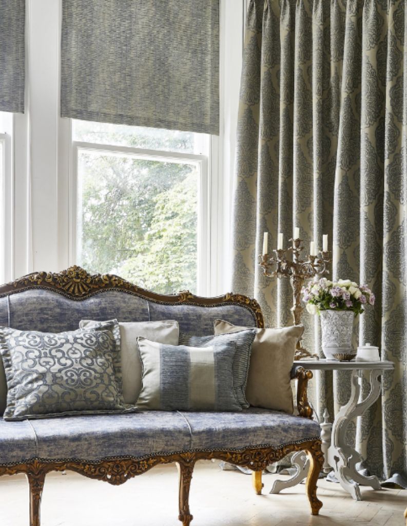 A regencycore living room with ornate sofas, cushions and curtains. 