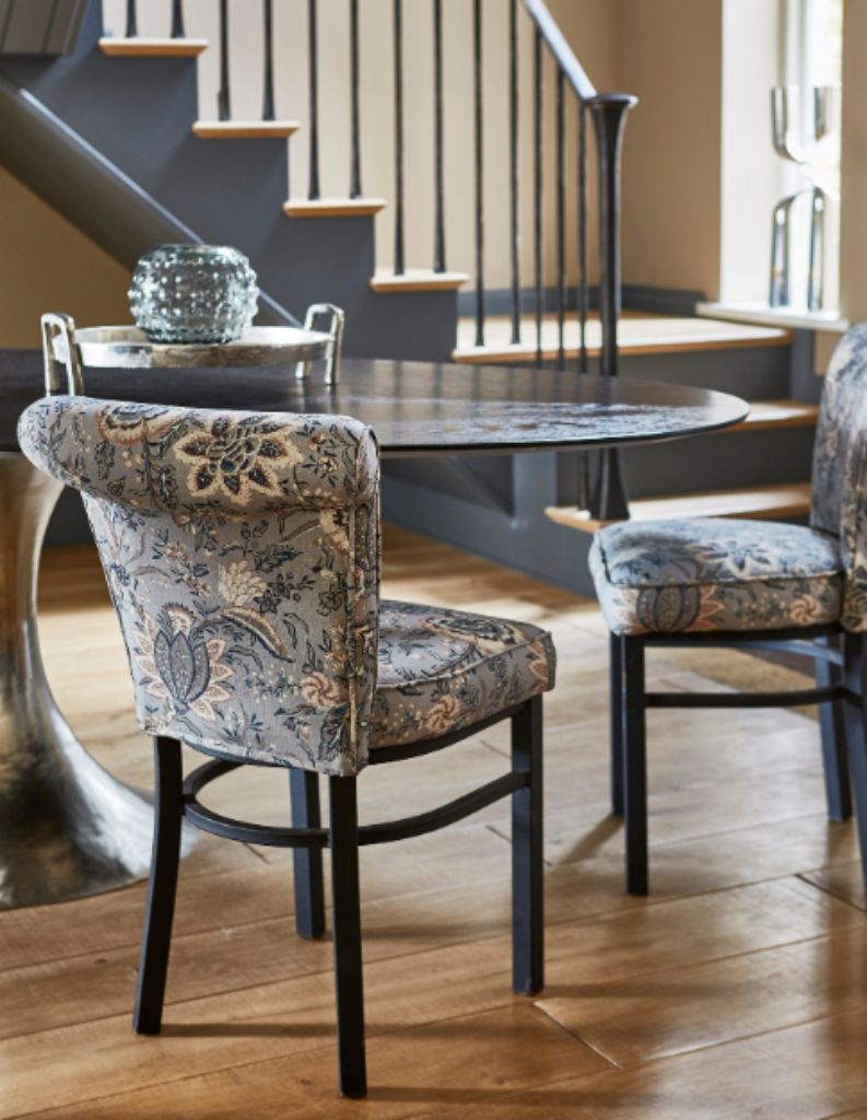 A regencycore inspired sitting area with patterned chairs and modern table.