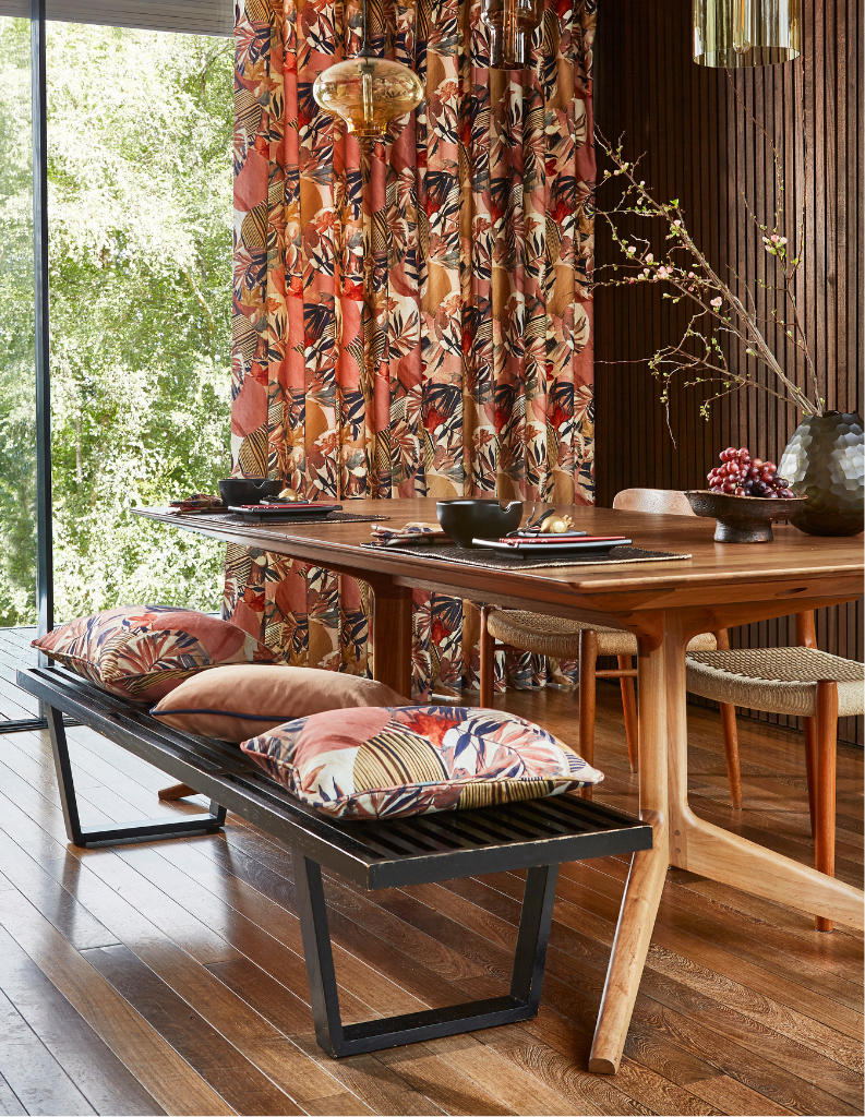 An autumn inspired dining room with orange curtains and cushions. 