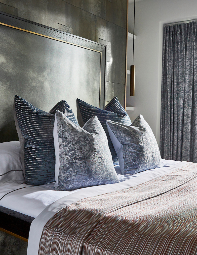 Chrome coloured cushions and curtains in a luxurious bedroom.