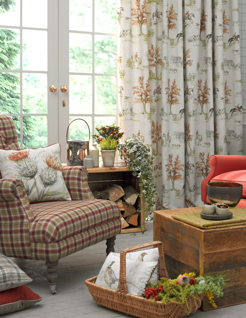 A tartan chair with tree patterned curtains in an autumn sitting room.  