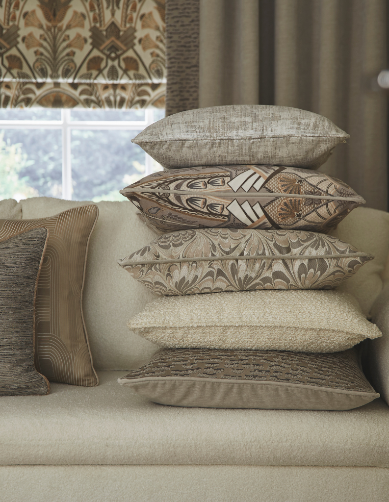 A series of patterned cushions and a floral Roman blind. 