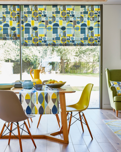 A mid-century modern dining room with patterned curtains.